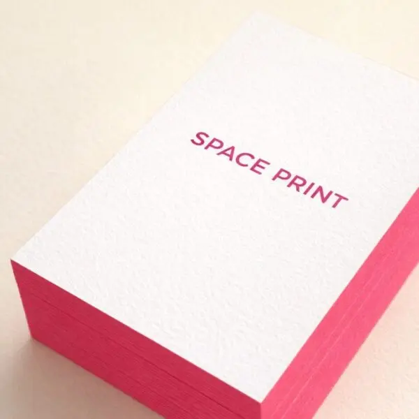 Stack of white cotton business cards with magenta painted edges