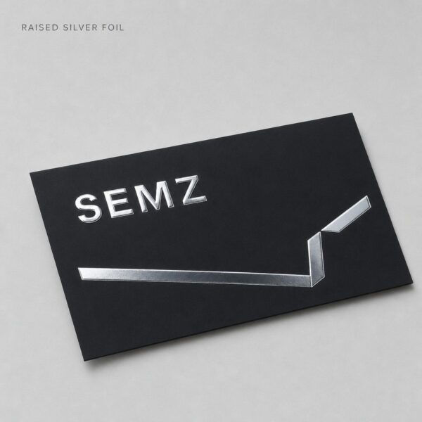 Black business card with raised silver foil logo catching the light